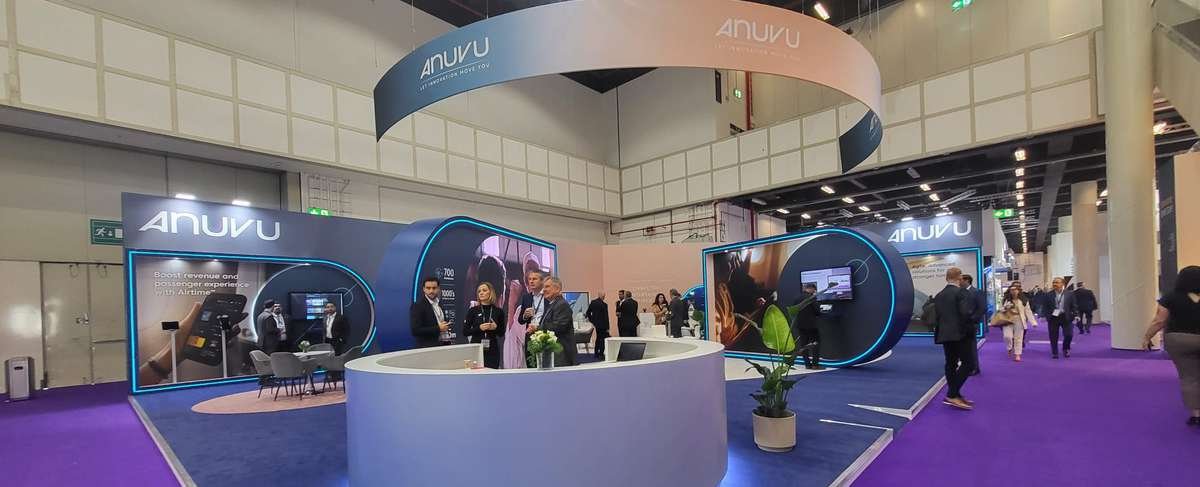 Anuvu exhibition stand with circular overhead branding and interactive displays at WTCE in Hamburg