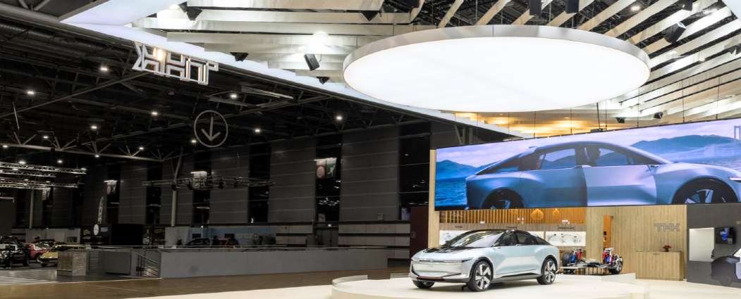 THK mobility exhibition stand with a full-width digital display and vehicle at the Paris Motor Show